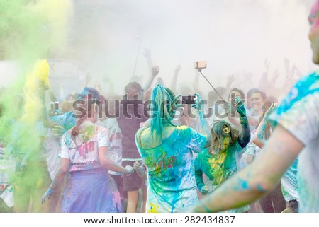 STOCKHOLM - MAY 23, 2015: The participator in the Color Run waving their arms in the air and taking photos in the public event The Color Run, May 23, 2015 in Stockholm, Sweden