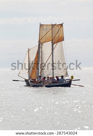 GRISSLEHAMN - JUN 13, 2015: One old sailing ship and sailors in vintage clothes in bright light rowing from Grisslehamn to Aland in the public event Postrodden, June 13, 2015 in Grisslehamn, Sweden