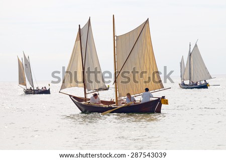 GRISSLEHAMN - JUN 13, 2015: Group of old sailing ships with female crew in bright light rowing from Sweden to Finland in the public event Postrodden, June 13, 2015 in Grisslehamn, Sweden