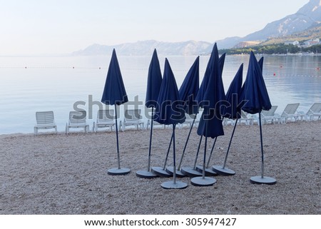 A group of deck chair and parasols on the beach in the first blue morning light Before the tourists arrive
