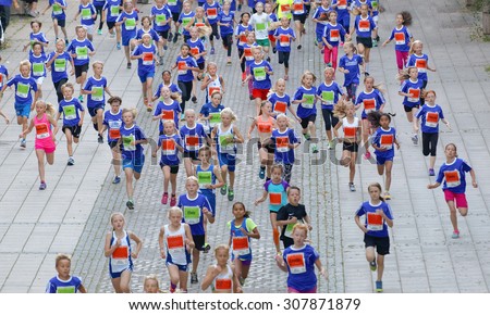 STOCKHOLM, SWEDEN - AUG 15, 2015: Large group of running girls and boys from above in the section for kids in the running event Midnattsloppet, August 15, 2015 in Stockholm, Sweden