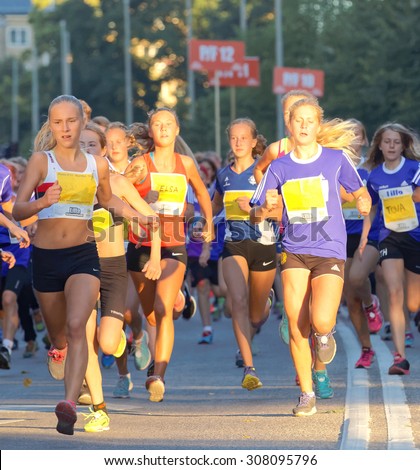 STOCKHOLM, SWEDEN - AUG 15, 2015: Group of 13 year old girls and boys running in the running event Midnattsloppet, August 15, 2015 in Stockholm, Sweden