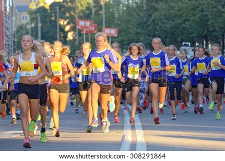 STOCKHOLM, SWEDEN - AUG 15, 2015: Group of 13 year old girls and boys running in the running event Midnattsloppet, August 15, 2015 in Stockholm, Sweden