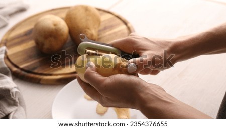 Image, Stock Photo Unrecognizable chef peeling potato in kitchen