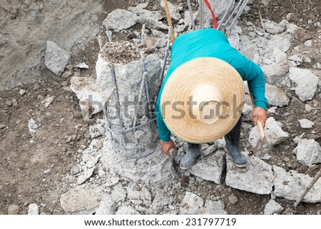 A construction worker cuts a concrete bored pile at pile's cut off level.