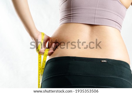fat woman, fat belly, chubby, obese woman hand pinching on her excessive belly fat waist with measure tape, woman diet lifestyle concept - rear view Сток-фото © 
