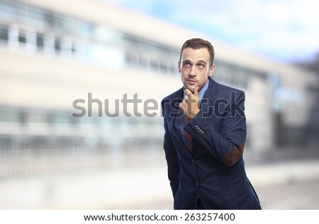 Man in suit thinking in front of building