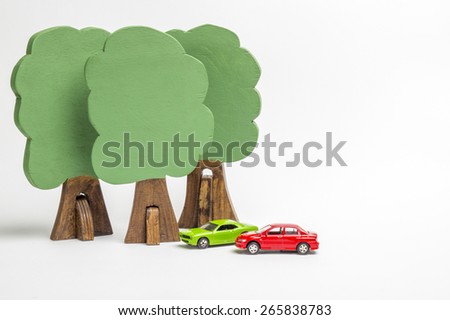 House of wooden blocks of different colors, three wooden figures of trees, euro money, three models of cars, keychains