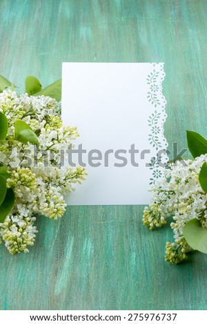white lilac, lilac purple, white sheet of paper with hearts punching, punching with flowers on turquoise background, on a brown background,