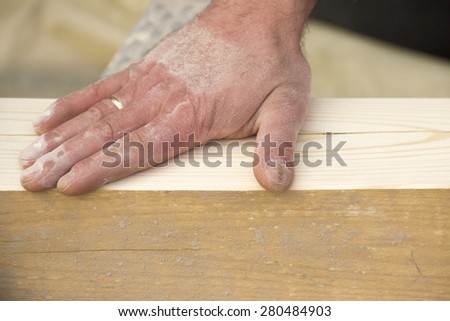 a man with a beard, a builder, working with wood, wood grinder grinds