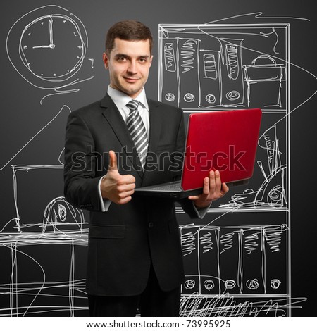 male businessman in suit with laptop in his hands, looking on camera