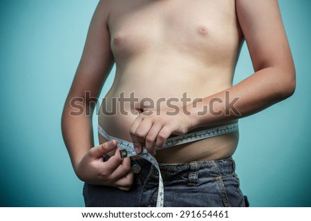Obese boy with measuring tape around stomach, Healthy and lose weight concept