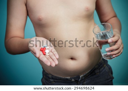 Obese boy holding a lot of pills, Healthy and lose weight concept