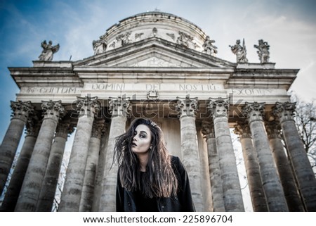Long hair girl with scary makeup on the old church background