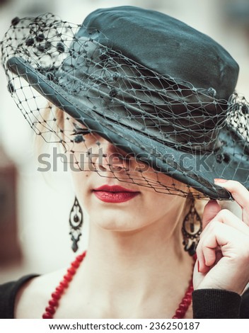 Young pretty sexy lady with red lips in black vintage hat outdoor