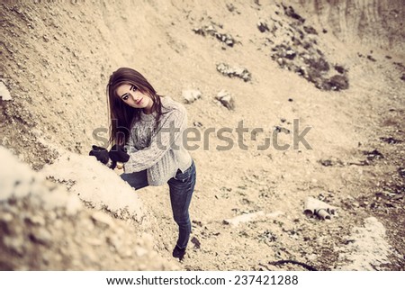 Pretty young woman outdoor in quarry with sand on background