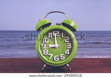 Clock on Wooden Floor with Blue Sea Background , Vintage Style