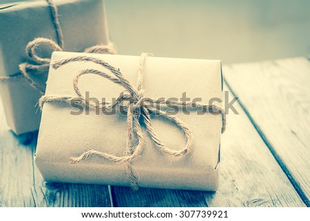 Vintage gift box brown paper wrapped with rope on wood background , vintage tone