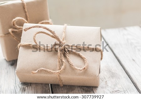 Vintage gift box brown paper wrapped with rope on wood background