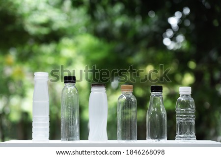 Many different shape drinking water bottles arrange into line with blur green garden background, re use container, eco friendly concept, copy space Foto stock © 