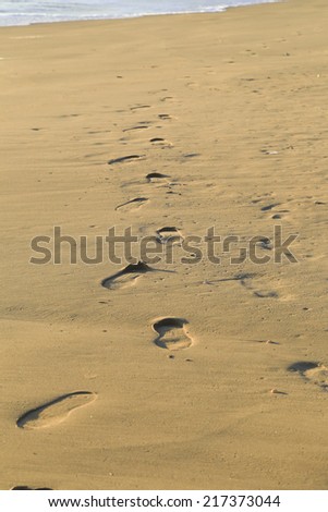 Sampieri, IT, February 2, 2013: walking on a Sicilian beach. Footprints on the beach