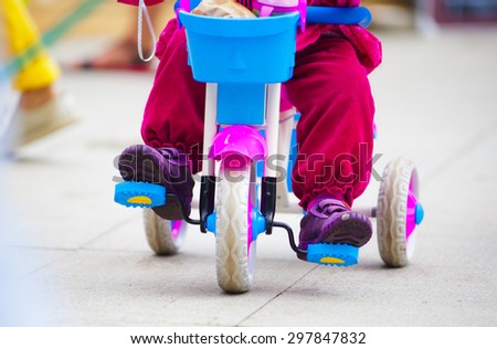 baby girl riding on a tiny bike front view