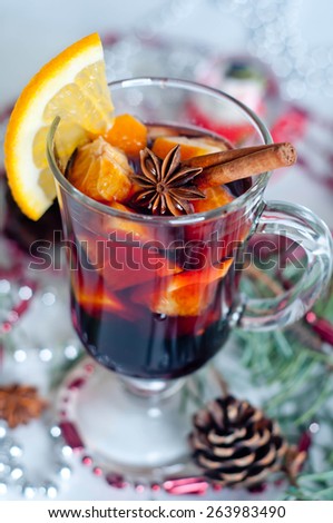 Hot red mulled wine isolated on white background with christmas spices, orange slice, anise and cinnamon sticks, close up.