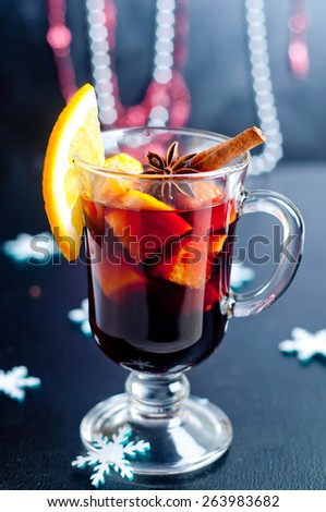 Hot red mulled wine isolated on white background with christmas spices, orange slice, anise and cinnamon sticks, close up.
