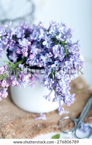 Bouquet of purple lilac spring flowers with a book and vintage hazy editing