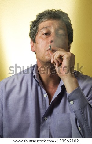 portrait of a man who takes a drag on a cigarette, the smoke will cover half his face