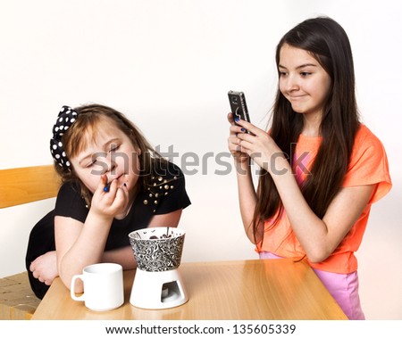 Children with Chocolate Fondue and mobil phone