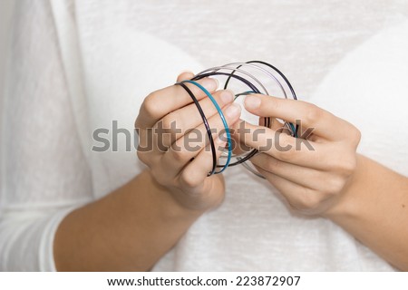 Young woman hands with jewelry, cyan, silver and black rings.  Girl hands with jewelry