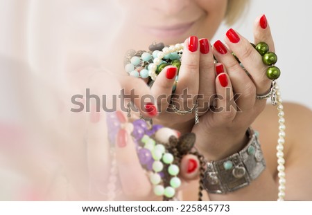 Bouquet of red nails and jewelry. Woman hands with red nails and jewelry