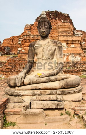 Buddha statue cover by the tree roots at Mahathat Temple, Ayutthaya, Thailand.