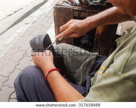 Shoes repair on sidewalk