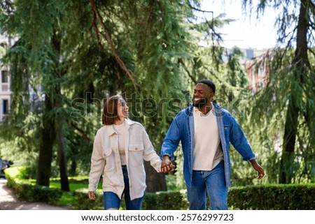 Image, Stock Photo Romantic multiethnic couple holding hands and strolling along city street