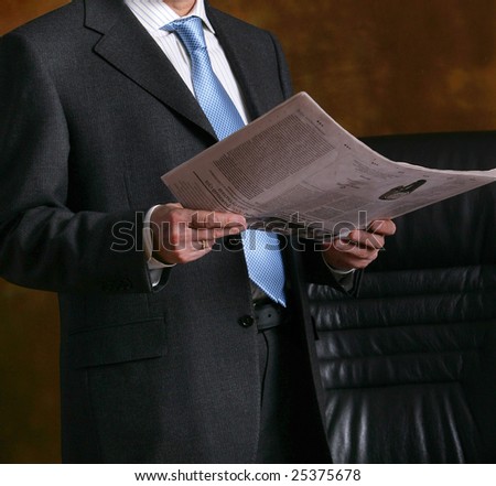 hand of a man in suit holding newspaper