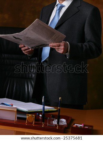 hand of a man in suit holding newspaper