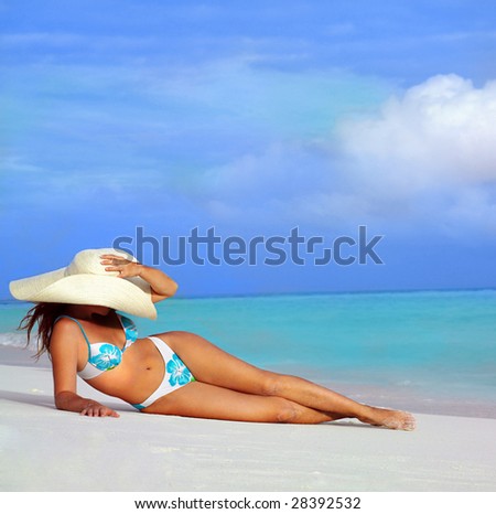 attractive woman in hat lying on the beach