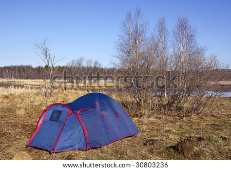 Blue tent standing at the  bare trees