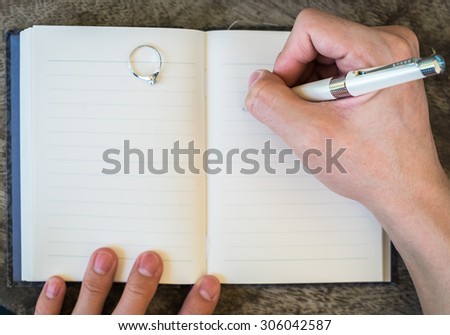 Hand writing white pen notebook diamond ring in memory