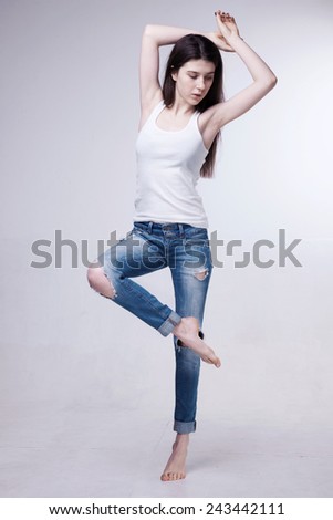 Beautiful sexy girl in jeans clothes posing on a white background isolated