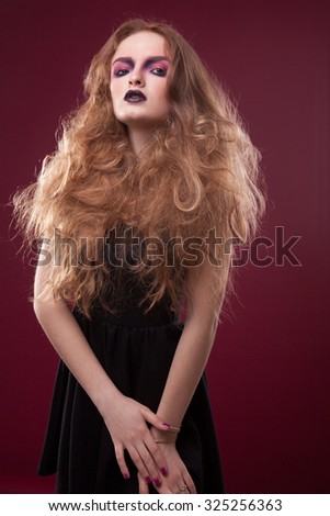 Closeup beautiful portrait of a young cute girl over white background. Woman with perfect bright makeup. Pink shadows and dark lips. Pretty blonde. With long hair. Light effect.