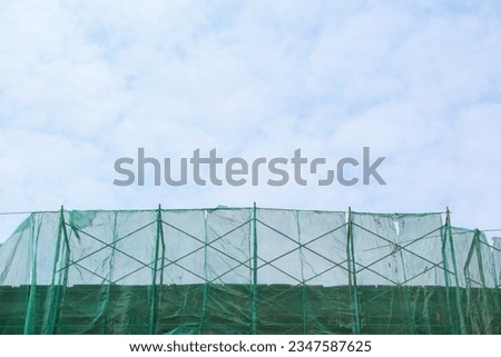 Similar – Image, Stock Photo Scaffolding with protective net and tarpaulin from frog perspective / house renovation