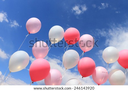 Balloons on threads against the sky and clouds