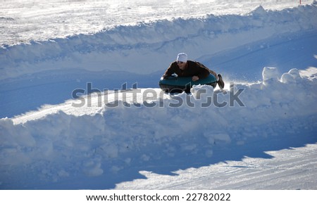 man tubing fast down the hill with snow background