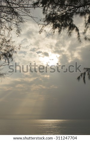 Landscape of cloudy sky which has sun beam and sea water in southern of Thailand (Use pine as picture frame)