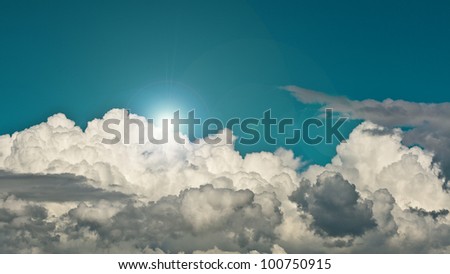 Blue sky, white and gray clouds and bright sun