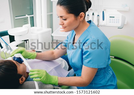 Pediatric dentist doing Inhalation Sedation to a child while teeth treatment at dental clinic. Sedation Dentistry Stock foto © 