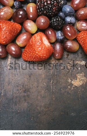 A Vertical Shot of A Group of Mixed Berries on a Dark Background. From Above, with Copy Space.